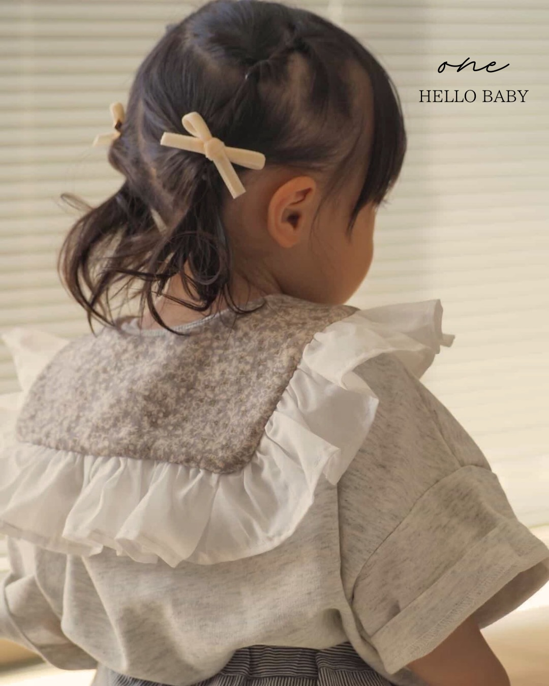 花柄と白いフリルのスタイを着けた子ども